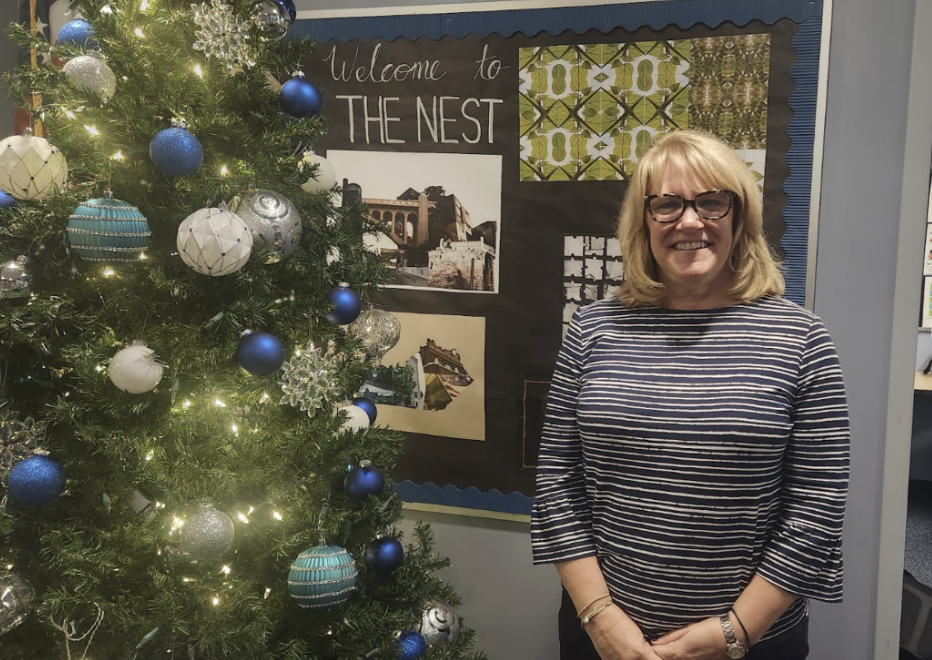 Bodner stands in front of the Christmas tree in the AP office. She retires on December 20th, leaving a legacy of positivity and kindness. 